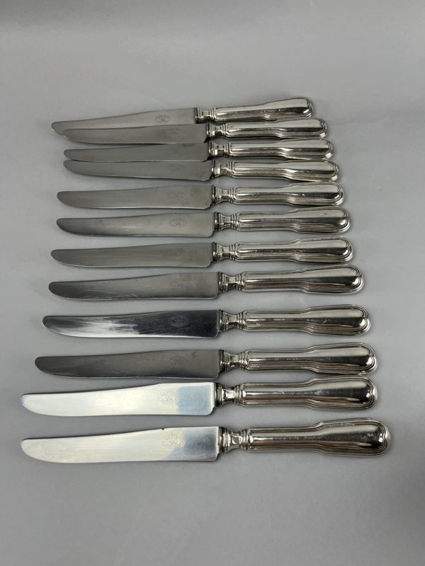 12 Couteaux de table en métal argenté modèle au filet
